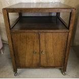 A 1960's wooden trolley / cabinet with record storage double door cupboard to base and shelf to top.