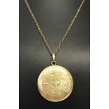 A large round rolled gold locket with engraved detail to front and back.