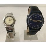 A blue dial leather strap Swatch watch together with a 2002 Irony stainless steel Swatch watch.