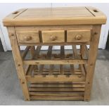 A modern pine kitchen butchers block with 3 storage drawers and wine rack.
