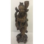 A Meiji period Japanese hardwood carved figure of a gentleman in traditional dress.