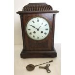 A Victorian wooden cased mantle clock with enamel face and classic detail.