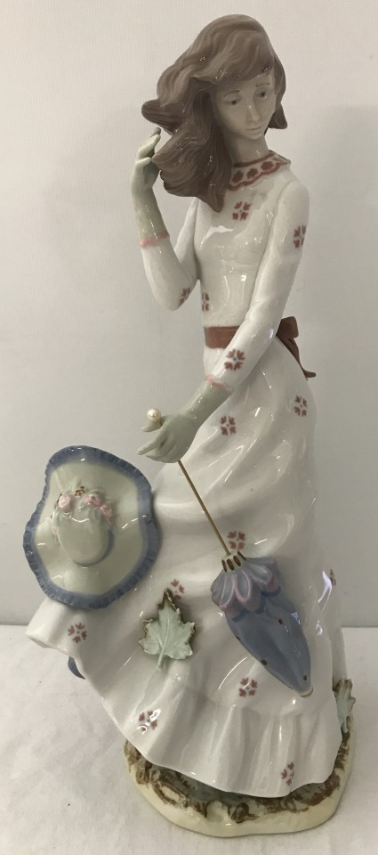 A large Nao figure " Windswept" # 0658 of a girl holding a parasol.
