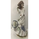A large Nao figure " Windswept" # 0658 of a girl holding a parasol.