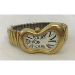 Gilt metal "Melting Clock" style softwatch wristwatch on expandable strap.