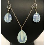 An earring and pendant set with reverse carved Pagodas in blue crystal on silver chain and fittings.