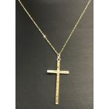 A 9ct gold cross with delicate engraved decoration on a fine 18 inch gold chain.