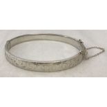 Hallmarked silver hinged bracelet with safety chain.