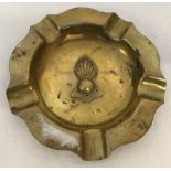 A brass ashtray set with "Ubique" insignia.