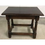A vintage side table in dark wood with turned legs