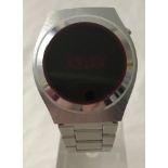 A vintage 1970's LED spaceman watch with red face and steel case and strap.