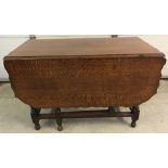 An oak drop leaf gate leg dining table with barley twist legs and pie crust edge.