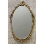 A modern reproduction metal framed oval wall hanging mirror.