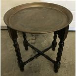 A vintage brass tray topped side table depicting oriental scene.
