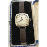 A vintage chrome cased Swiss made cushion cased watch on brown leather strap.