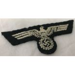 A white embroidered German Uniform cloth eagle insignia.