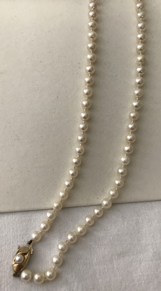 A single strand of ivory uniform cultured pearls with pearl set 9ct gold clasp.