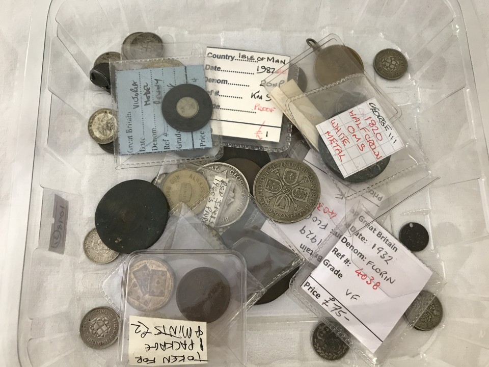 A tray of old coins and tokens.