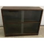 A dark oak glass fronted display cabinet.