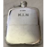 An antique silver hip flask with twist cap top. Engraved monogram to front M.I.N.