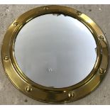 A brass surround convex port hole style mirror.