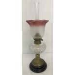 A vintage oil lamp with glass bowl and clear & cranberry coloured etched glass shade.