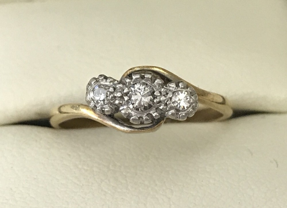 An 18ct gold and platinum diamond set trilogy ring. Approx. diamond carat .15ct