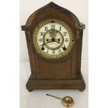 A vintage wooden cased Ansonia Clock Co mantel clock with ceramic skeleton dial.