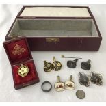 A vintage burgundy coloured jewellery box containing a small quantity of assorted jewellery items.