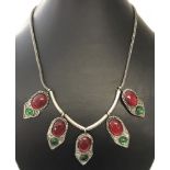 A white metal ethnic style necklace with red and green glass cabochons.