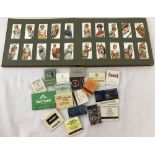 A vintage Players cigarette card album together with a small collection of match books and boxes.