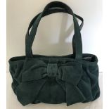 A green suede Kaliko handbag with bow detail.