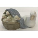 A small Lladro ceramic figurine of a mother duck with a basket of ducklings.