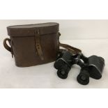 A leather cased pair of vintage binoculars.