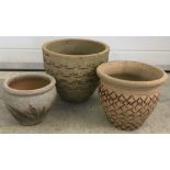 3 round terracotta garden planters with decoration to sides.