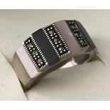 A 925 silver band ring set with panels of Onyx, pale pink pearl and marcasite.