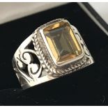 A 925 silver dress ring with cut out scroll work and a central square cut citrine.