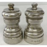 A hallmarked silver over wooden body salt and pepper grinder cruet set.
