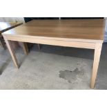 A modern light oak effect rectangular dinning table.