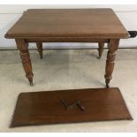 A vintage oak winding draw leaf dining table with turned legs on ceramic castors.