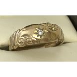 A 9ct gold diamond set gypsy style ring with scroll design to top.