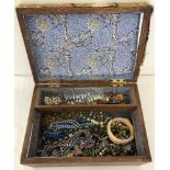 A wooden box containing vintage glass and bead jewellery.