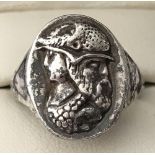 An unusual silver signet ring decorated with the faces of multiple men.