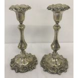 A decorative pair of silver plated candlesticks with removable sconces.