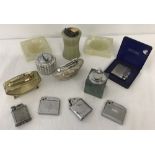 A collection of assorted vintage pocket and table lighters and ashtrays.