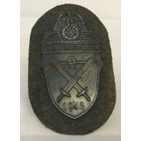 German WWII pattern Demjansk Campaign shield on green cloth backing.