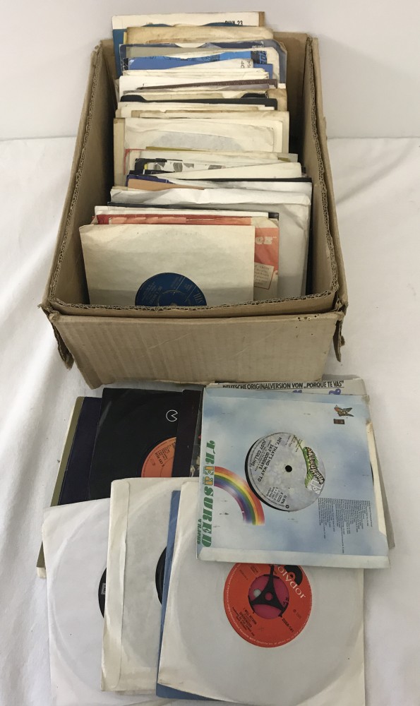 A box of assorted vintage 45rpm vinyl records, approx. 100 in total.