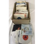 A box of assorted vintage 45rpm vinyl records, approx. 100 in total.