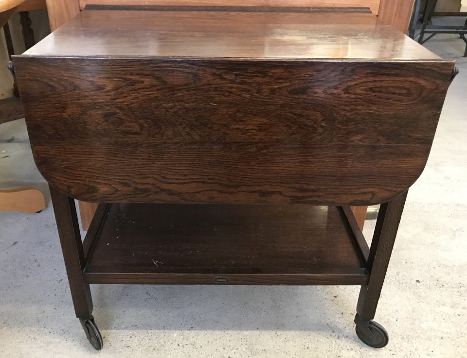 A small dark oak dual action lift drop leaf tea trolley.