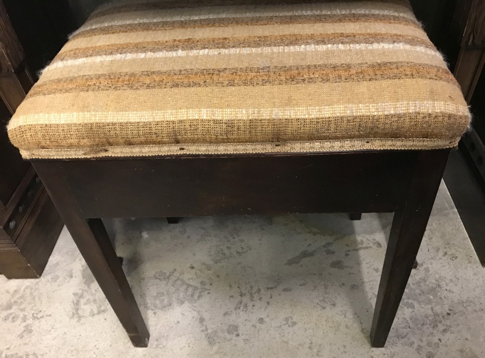 A vintage mahogany piano stool with brown upholstered cushion top.